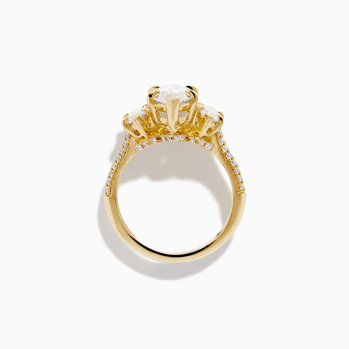 The Lab Grown Marquise Diamond 3 Stone Ring in 14K Yellow Gold features a central lab-grown marquise diamond, flanked by two pear-shaped diamonds with additional smaller stones adorning the band, shown on a white background.
