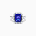 The Effy Hematian 18K White Gold Tanzanite and Diamond Halo Ring showcases a large rectangular blue tanzanite at the center, encircled by a diamond halo with additional diamonds set along the band.