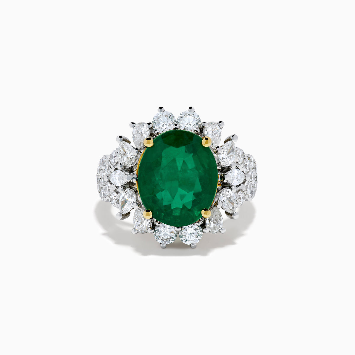 The 18K Two-Tone Gold Emerald, Yellow and White Diamond Ring features a striking oval green emerald surrounded by white diamonds, set in a gold and silver band with gold prongs, shown against a plain white background.