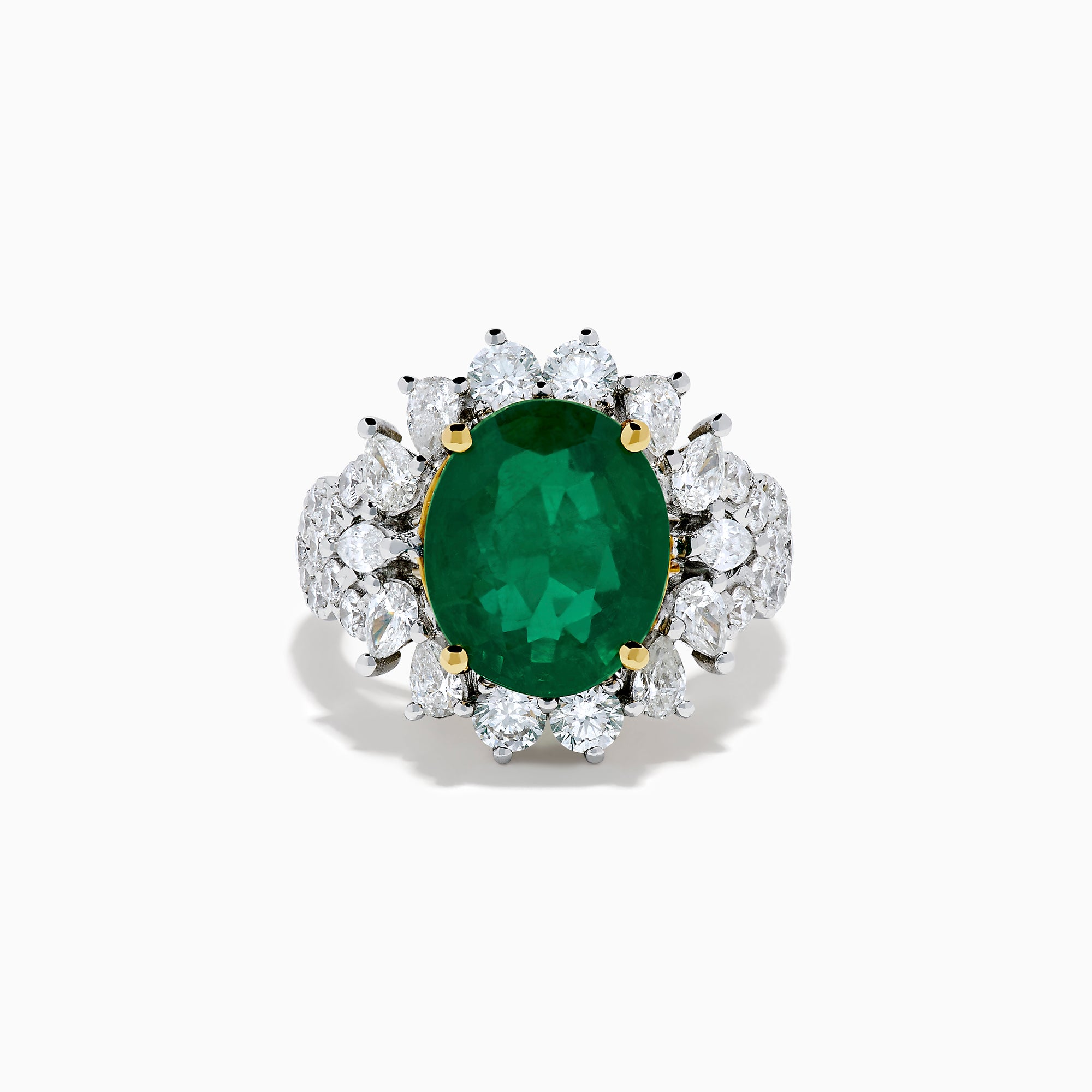 The 18K Two-Tone Gold Emerald, Yellow and White Diamond Ring features a striking oval green emerald surrounded by white diamonds, set in a gold and silver band with gold prongs, shown against a plain white background.