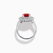 The 18K White Gold Ruby and Diamond Double Halo Ring features an oval ruby encircled by double diamond halos on a sleek white gold band, showcased against a white background.