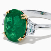 The Effy Hematian 14K Two Tone Gold Emerald and Diamond Three-Stone Ring features a large oval emerald center set with four gold prongs, flanked by two clear rectangular diamonds on a gold and silver band.