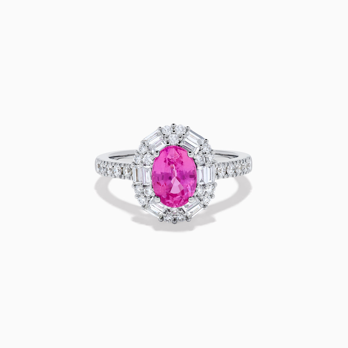 The 18K White Gold Pink Sapphire and Diamond Halo Ring showcases an oval pink sapphire center, encircled by a halo of baguette and round-cut diamonds, with more diamonds adorning the band.