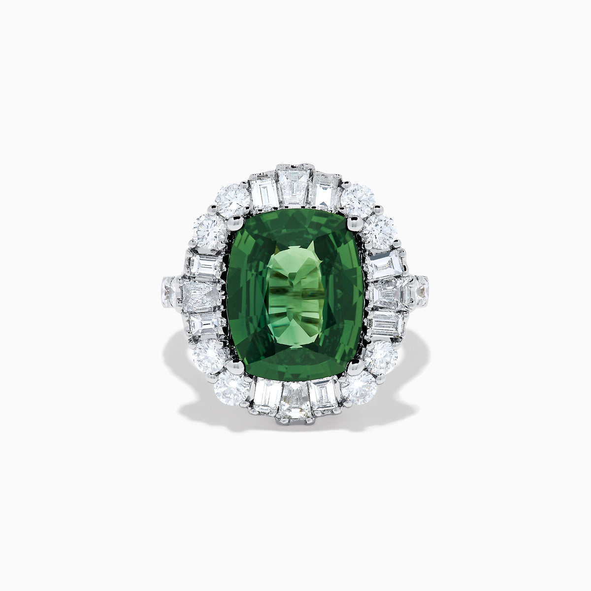 The 18K White Gold Green Sapphire and Diamond Halo Ring showcases a large oval green sapphire, surrounded by round and rectangular white diamonds, set on an elegant white gold band and displayed on a white background.