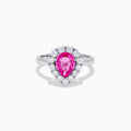 The 18K White Gold Pink Sapphire and Diamond Halo Ring features a pear-shaped pink sapphire center, accented by a sparkling diamond halo, elegantly displayed against a plain white background.