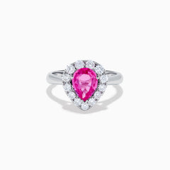 The 18K White Gold Pink Sapphire and Diamond Halo Ring features a pear-shaped pink sapphire center, accented by a sparkling diamond halo, elegantly displayed against a plain white background.