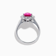 The 18K White Gold Pink Sapphire and Diamond Halo Ring features a pear-shaped pink sapphire center, accented by a sparkling diamond halo, elegantly displayed against a plain white background.