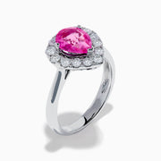The 18K White Gold Pink Sapphire and Diamond Halo Ring features a pear-shaped pink sapphire center, accented by a sparkling diamond halo, elegantly displayed against a plain white background.