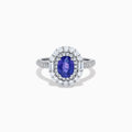 The 18K White Gold Purple Sapphire and Diamond Double Halo Ring features an oval purple sapphire center, two rows of white diamonds encircling it, and additional diamonds set along the band.