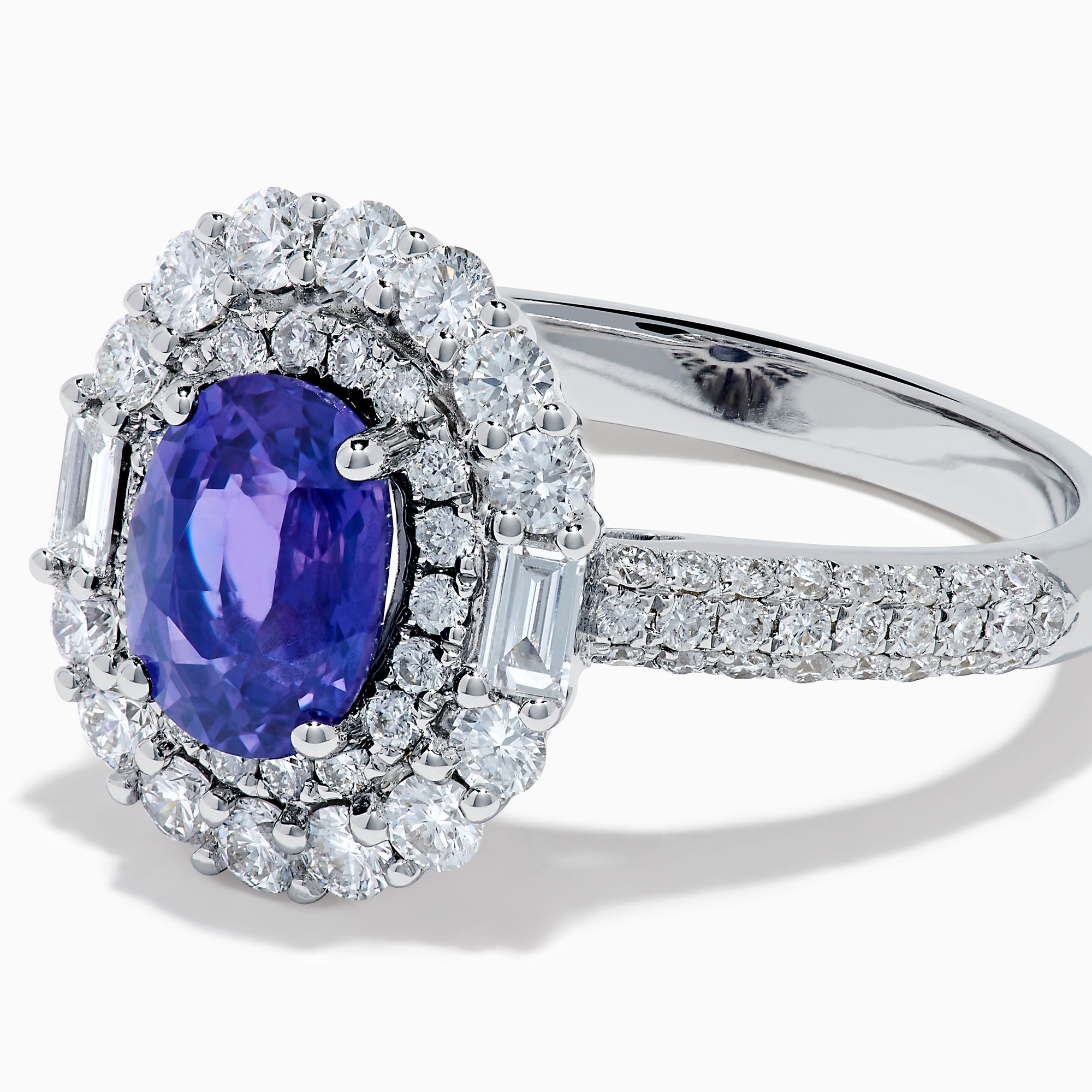 The 18K White Gold Purple Sapphire and Diamond Double Halo Ring features an oval purple sapphire center, two rows of white diamonds encircling it, and additional diamonds set along the band.