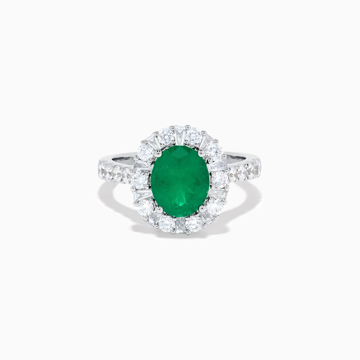 The Effy Hematian 18K White Gold Oval Emerald and Diamond Halo Ring features a vibrant oval emerald at the center, surrounded by a sparkling diamond halo with additional diamonds set along the elegant band.