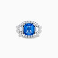 The Effy Hematian 18K Gold Cushion-Cut Blue Sapphire and Diamond Ring features a striking cushion-cut blue sapphire surrounded by a halo of round and baguette diamonds, all set in polished white 18K gold.