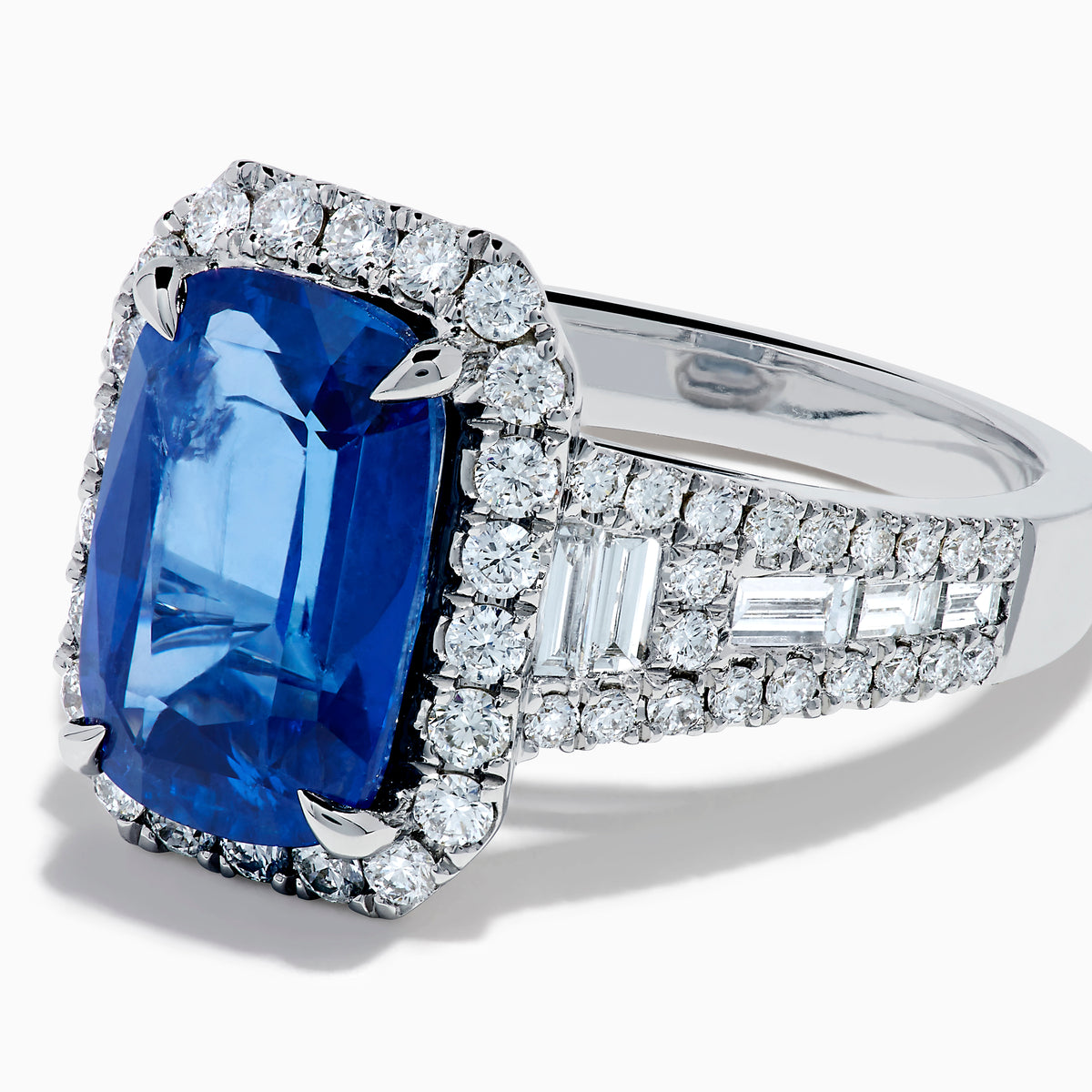 The Effy Hematian 18K Gold Elongated Cushion Blue Sapphire and Diamond Ring features a striking blue sapphire framed by round and baguette diamonds, with additional diamond accents along the split shank band.
