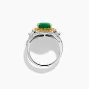 The 18K Gold Emerald, Yellow and White Diamond Double Halo Ring features a large oval green emerald center, surrounded by double halos of yellow and white diamonds with side diamonds on an 18K gold band. Set against a plain white background.