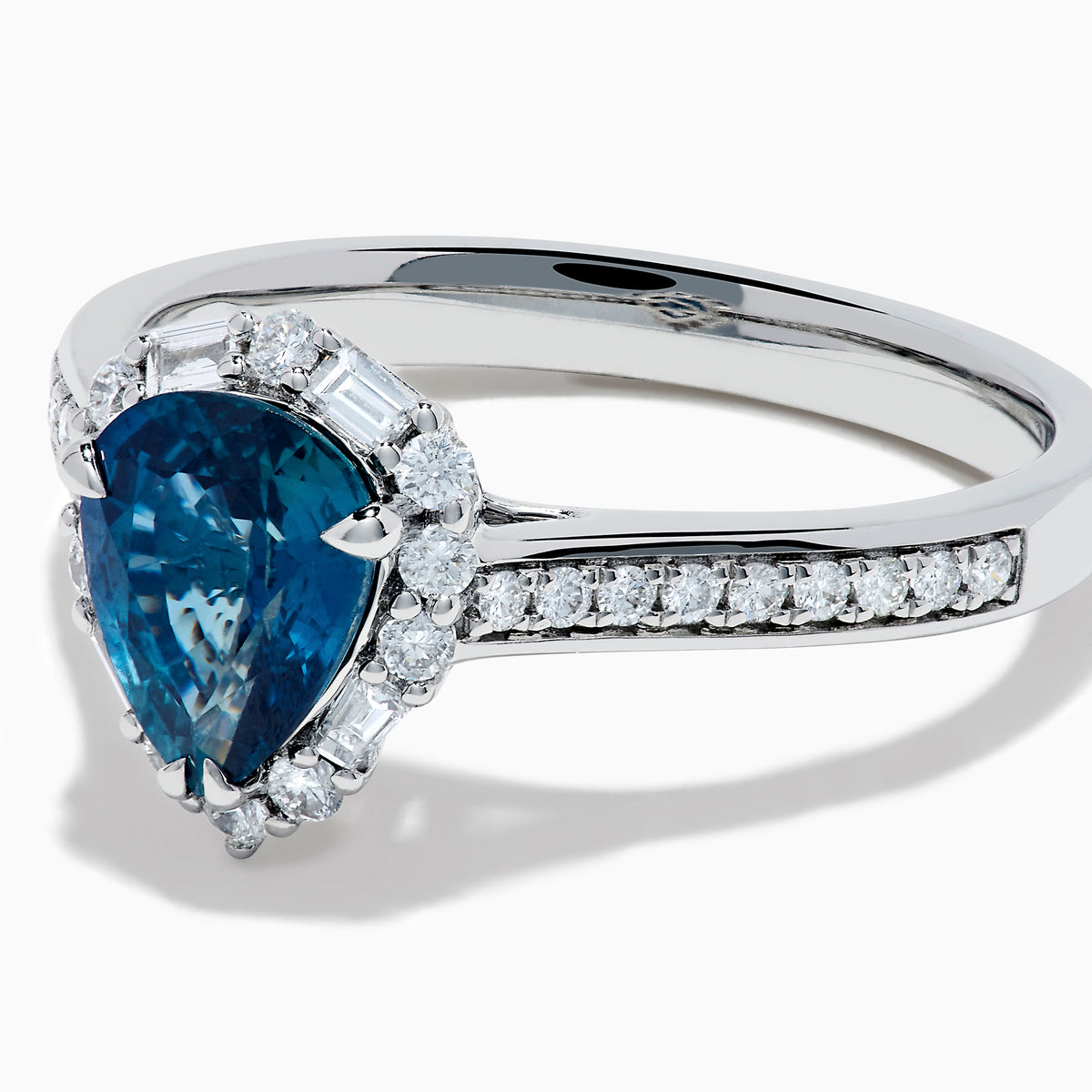 The Effy Hematian 18K White Gold Ring features a pear-shaped blue sapphire, surrounded by a halo of diamonds and set on a diamond-studded band, elegantly displayed against a white background.