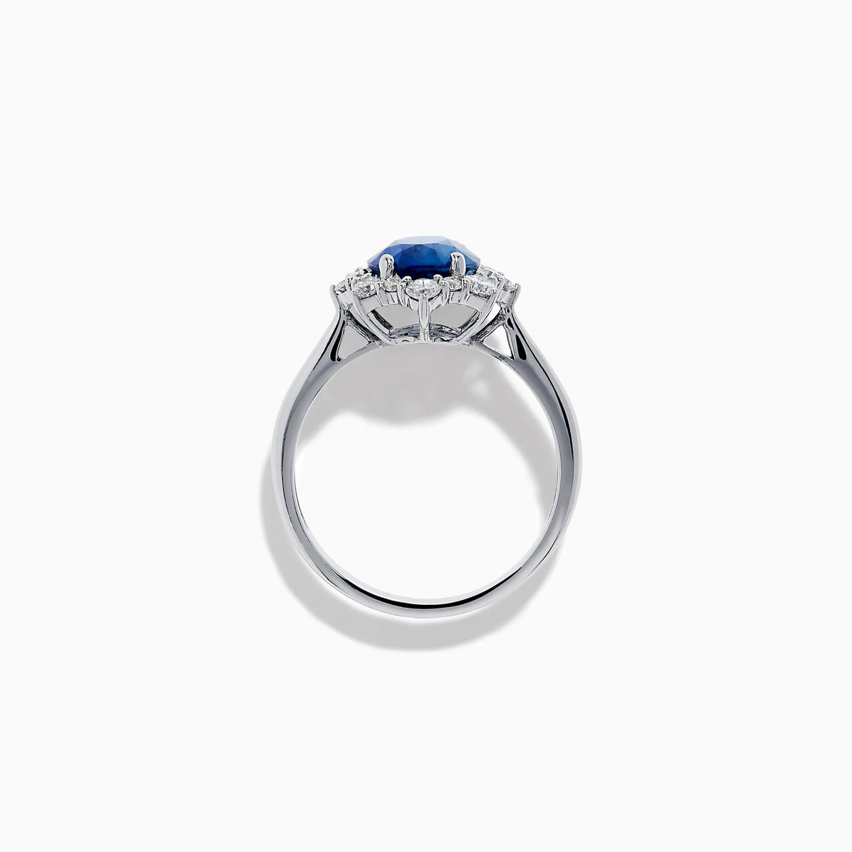 The Effy Hematian 14K White Gold Blue Sapphire and Diamond Halo Ring showcases an oval blue sapphire center, surrounded by a halo of sparkling round white diamonds, presented against a white background.