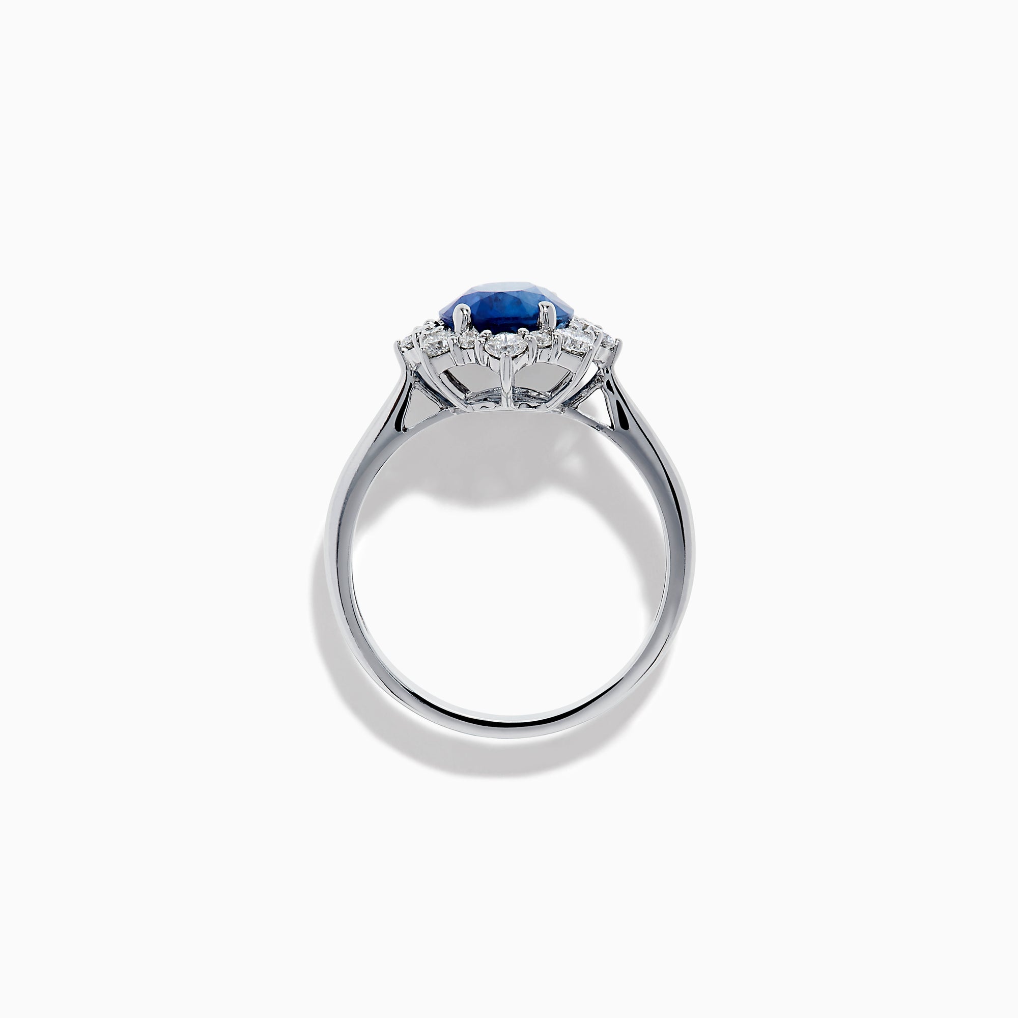 The Effy Hematian 14K White Gold Blue Sapphire and Diamond Halo Ring showcases an oval blue sapphire center, surrounded by a halo of sparkling round white diamonds, presented against a white background.