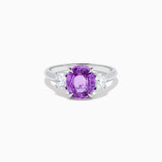 The Effy Hematian 18K White Gold Purple Sapphire and Diamond Three-Stone Ring features a large oval purple sapphire at the center with two smaller diamonds, shown on a white background.