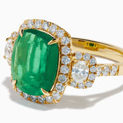 The Effy Hematian 18K Yellow Gold Emerald and Diamond Three Stone Ring features a large cushion-cut emerald, haloed by round white diamonds and accented with diamond clusters for a modern twist on the classic three stone style.