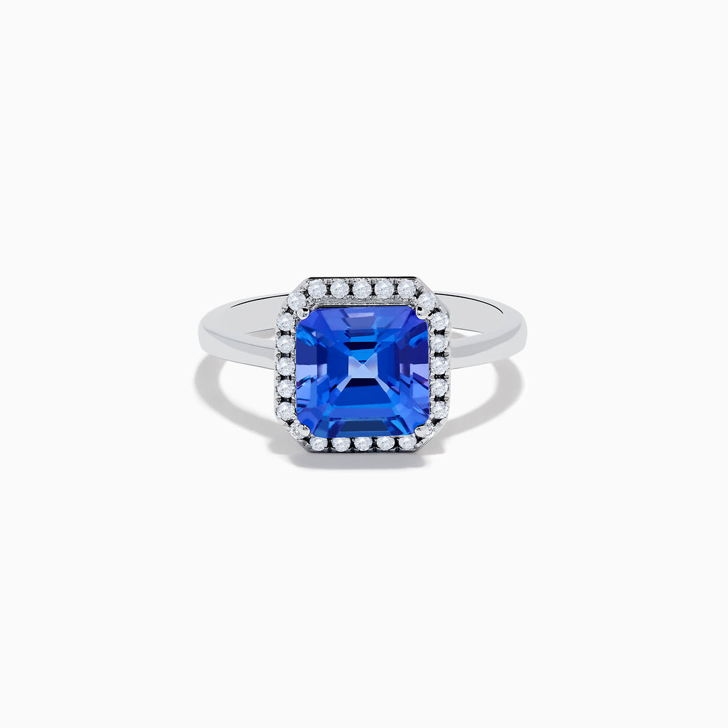 The Nahla Siri 14K Gold Tanzanite and Diamond Ring features a large emerald-cut tanzanite centerpiece, surrounded by a halo of sparkling diamonds, set in elegant gold and showcased against a white background.