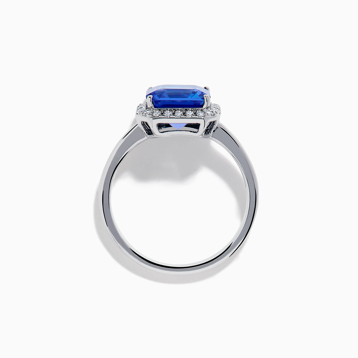 The Nahla Siri 14K Gold Tanzanite and Diamond Ring features a large emerald-cut tanzanite centerpiece, surrounded by a halo of sparkling diamonds, set in elegant gold and showcased against a white background.