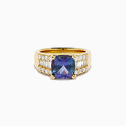The 18K Yellow Gold GIA Certified Zoisite and Diamond Ring showcases a large square-cut zoisite center stone with rows of round and rectangular diamonds on each side, all set in elegant yellow gold.