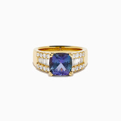 The 18K Yellow Gold GIA Certified Zoisite and Diamond Ring showcases a large square-cut zoisite center stone with rows of round and rectangular diamonds on each side, all set in elegant yellow gold.