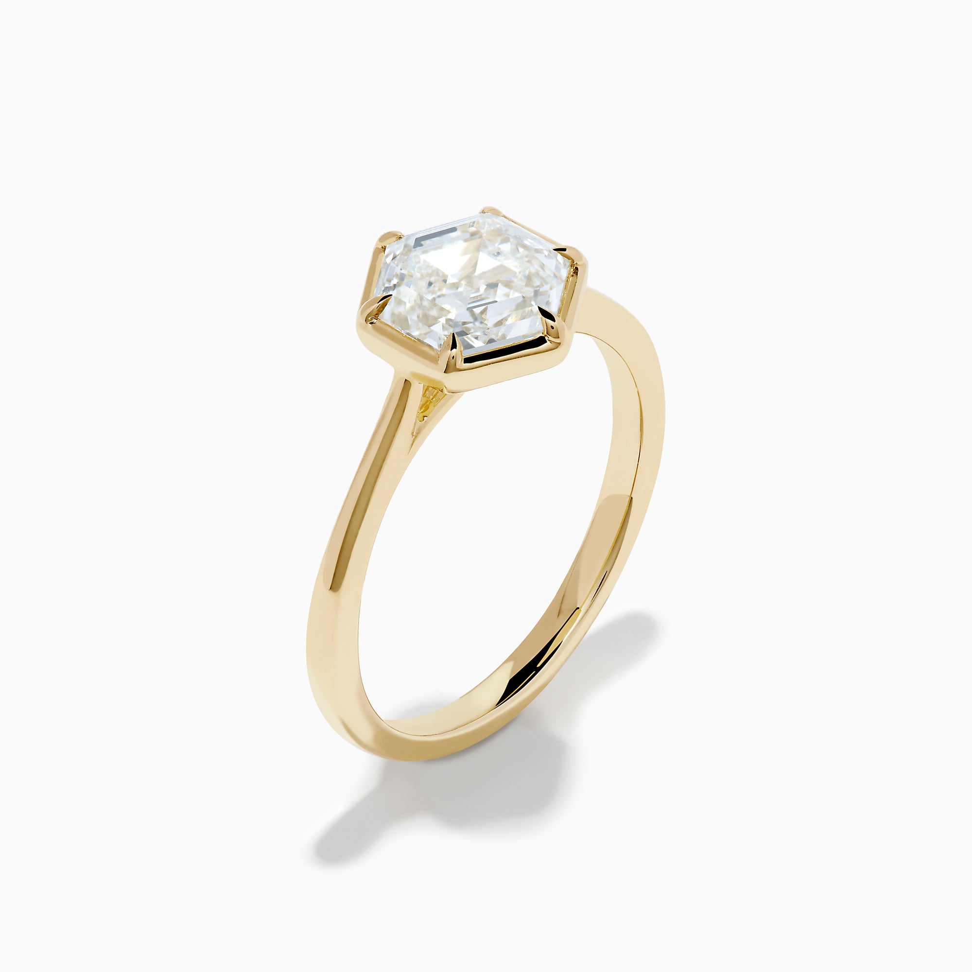The Lab Grown Diamond 2.00ct Hexagon Solitaire Ring in 14K Yellow Gold showcases a hexagon-shaped, lab grown diamond with a geometric stepped cut, set on a sleek, polished gold band and displayed against a white background.