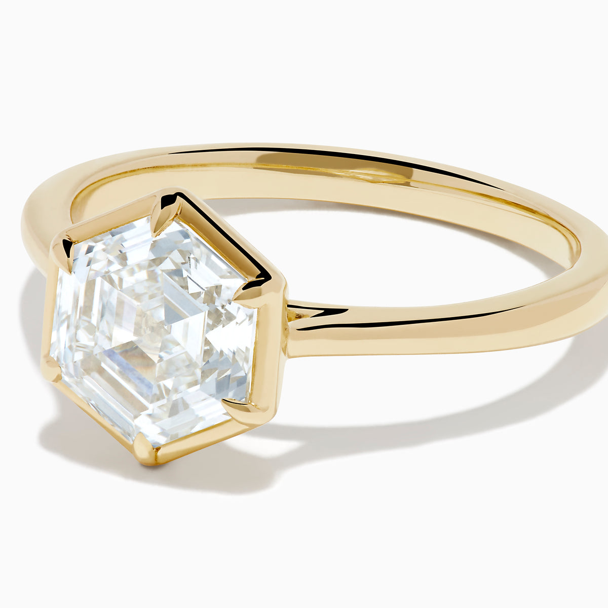 The Lab Grown Diamond 2.00ct Hexagon Solitaire Ring in 14K Yellow Gold showcases a hexagon-shaped, lab grown diamond with a geometric stepped cut, set on a sleek, polished gold band and displayed against a white background.