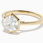The Lab Grown Diamond 2.00ct Hexagon Solitaire Ring in 14K Yellow Gold showcases a hexagon-shaped, lab grown diamond with a geometric stepped cut, set on a sleek, polished gold band and displayed against a white background.