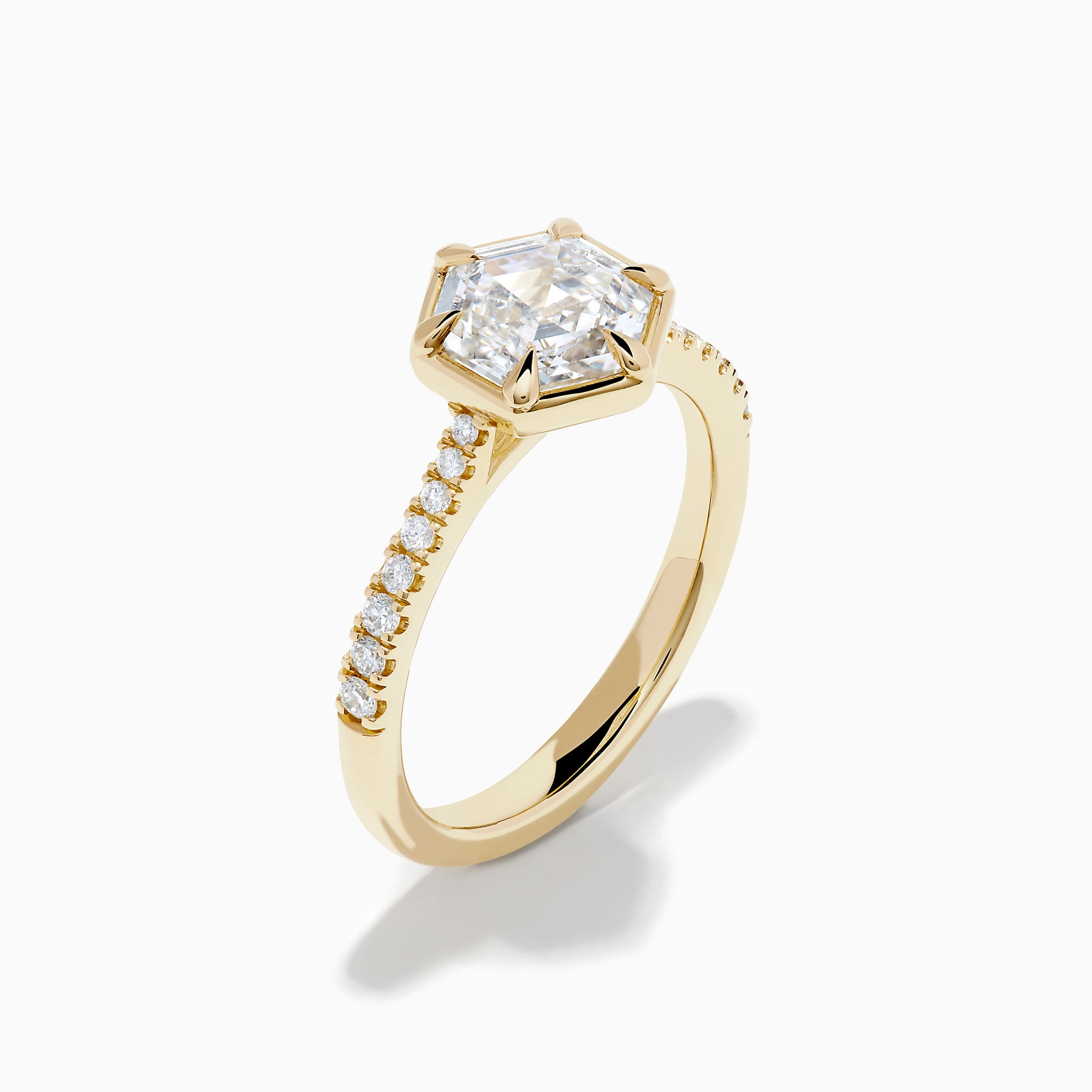 Presenting the Lab Grown Diamond 2.00ct Hexagon with Pave Band Ring in 14K Yellow Gold: a striking ring with a hexagonal-cut lab grown diamond at its center, accented by sparkling pave-set diamonds along the polished 14K yellow gold band, showcased on a clean white background.