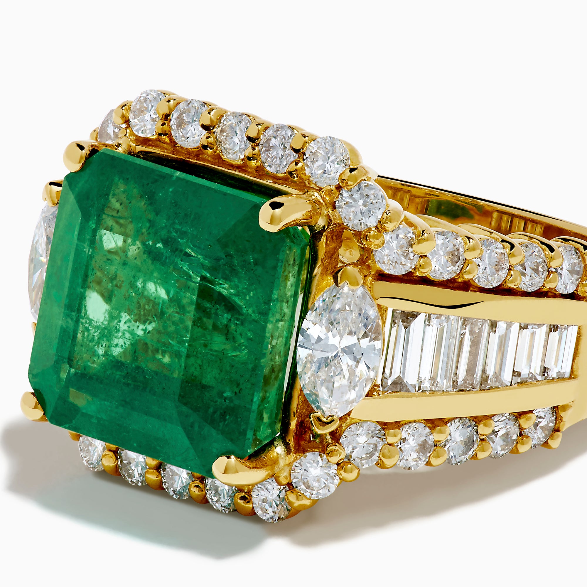 The 18K Yellow Gold Emerald and Diamond Ring features a large square green emerald center, encircled by round and baguette-cut white diamonds along the band and around the emerald, set against a white background.
