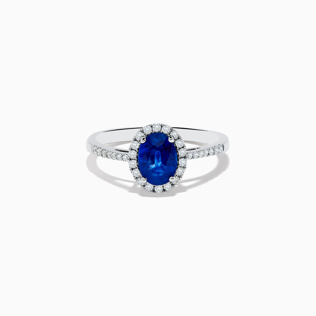 The 14K White Gold Oval Blue Sapphire and Diamond Ring features an oval blue sapphire center, a halo of sparkling diamonds, and additional diamonds set along the band.