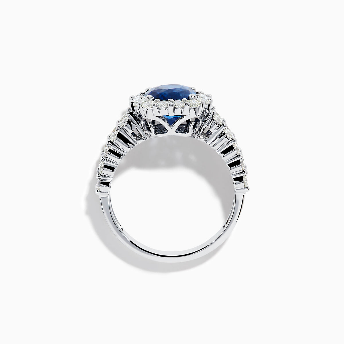 The 18K White Gold GIA Certified Cushion Cut Blue Sapphire and Diamond Ring features a striking cushion cut blue sapphire center, round diamond halo, and baguette-cut diamonds on the band, shown against a white background.