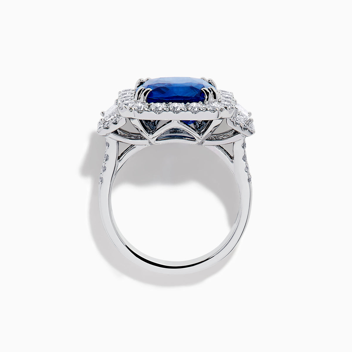 The Royale Bleu 18K White Gold Blue Sapphire and Diamond Halo Ring showcases a cushion-cut blue sapphire center with a double diamond halo and diamond side accents, elegantly set against a white background.