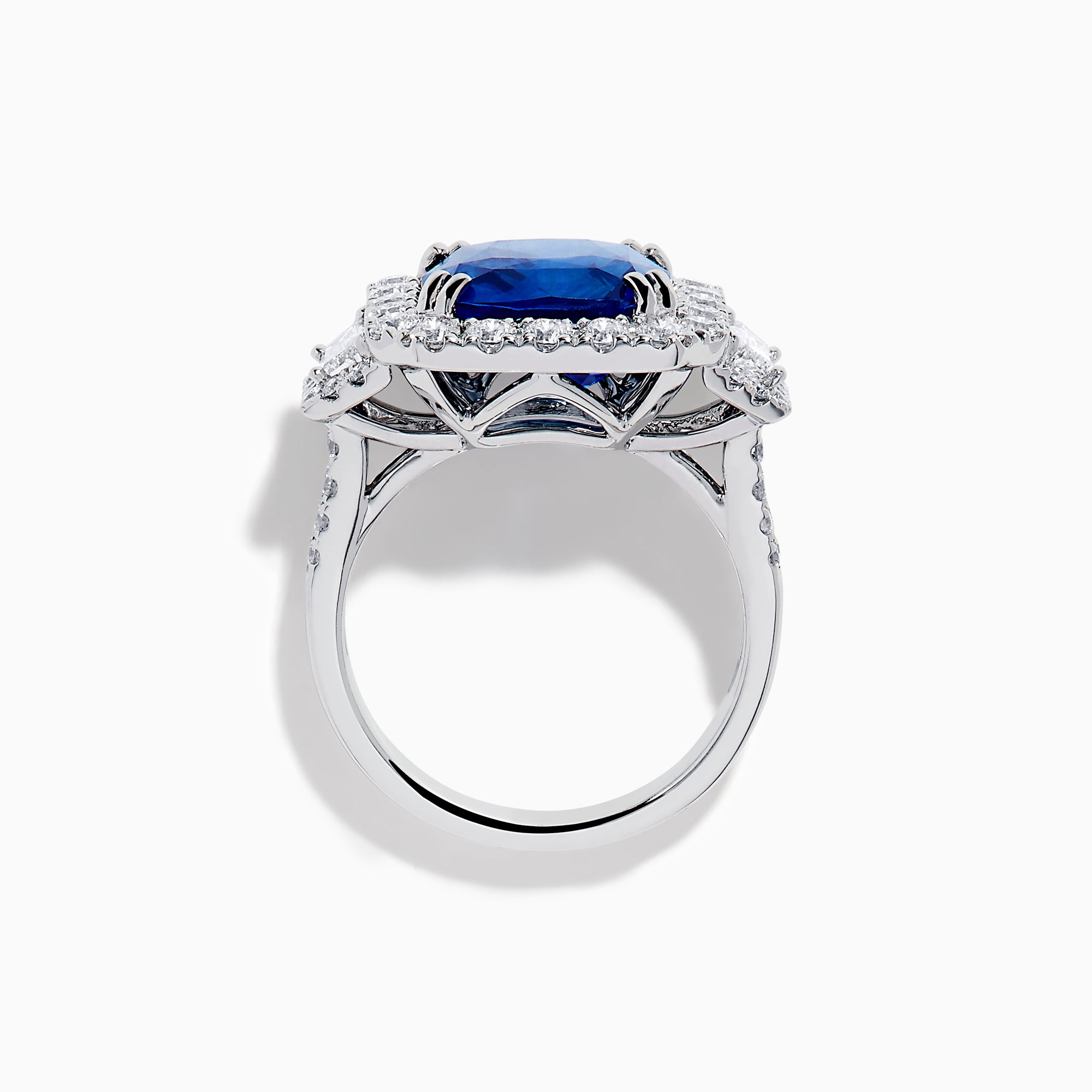 The Royale Bleu 18K White Gold Blue Sapphire and Diamond Halo Ring showcases a cushion-cut blue sapphire center with a double diamond halo and diamond side accents, elegantly set against a white background.