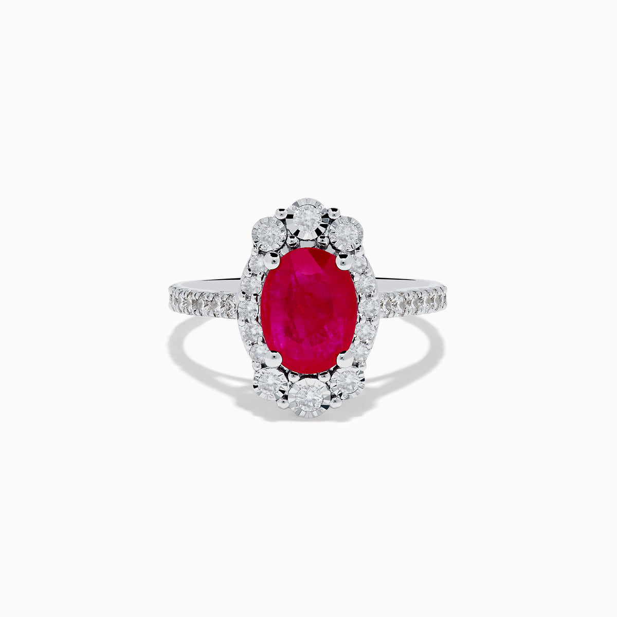 The Ruby Royale 14K White Gold Ruby and Diamond Ring showcases an oval red ruby center, a halo of round white diamonds, and additional diamonds along the band.