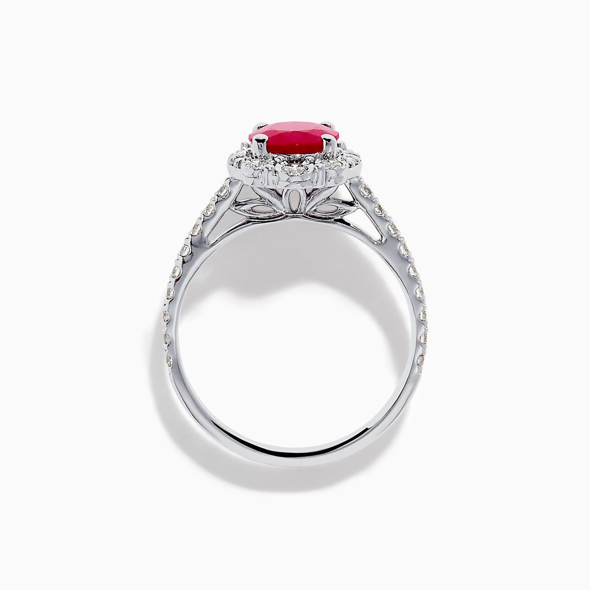 The Ruby Royale 14K White Gold Ruby and Diamond Ring showcases an oval red ruby center, a halo of round white diamonds, and additional diamonds along the band.