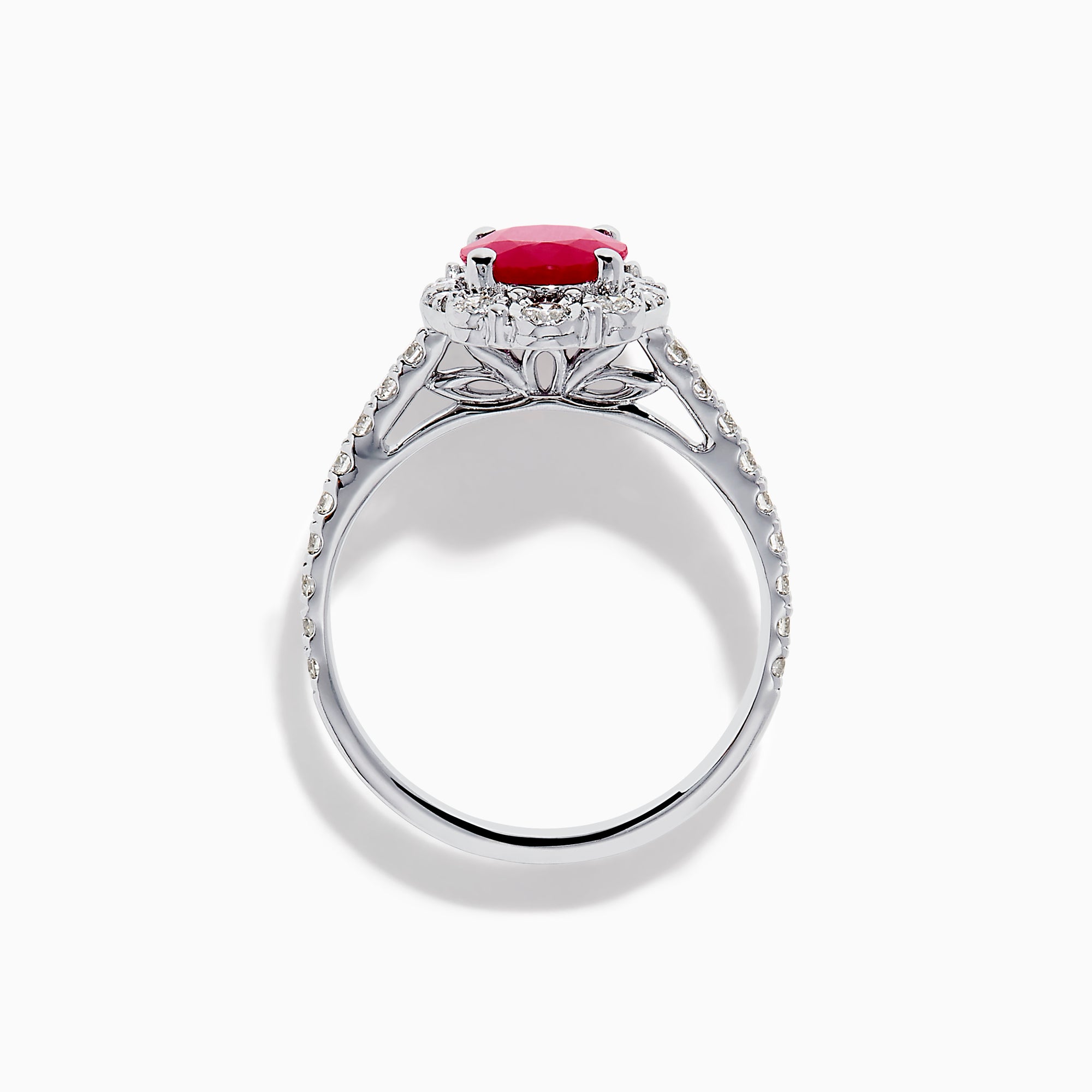 The Ruby Royale 14K White Gold Ruby and Diamond Ring showcases an oval red ruby center, a halo of round white diamonds, and additional diamonds along the band.
