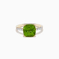 The 14K Yellow Gold Peridot and Diamond Ring features a large cushion-cut peridot at the center, accented by small diamonds set along the band on either side.