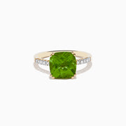 The 14K Yellow Gold Peridot and Diamond Ring features a large cushion-cut peridot at the center, accented by small diamonds set along the band on either side.