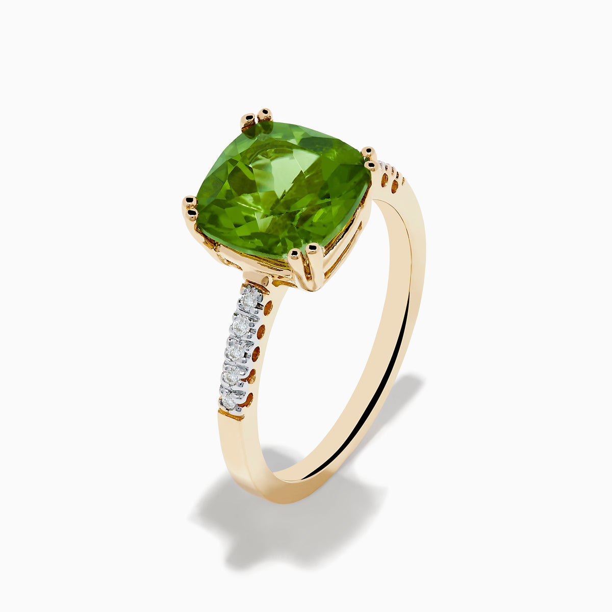 The 14K Yellow Gold Peridot and Diamond Ring features a large cushion-cut peridot at the center, accented by small diamonds set along the band on either side.