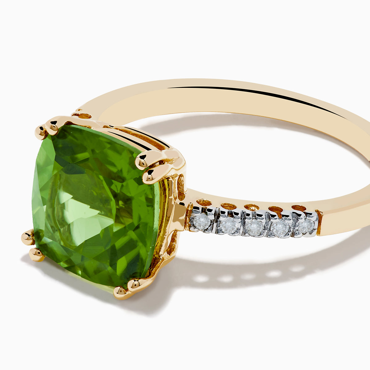 The 14K Yellow Gold Peridot and Diamond Ring features a large cushion-cut peridot at the center, accented by small diamonds set along the band on either side.