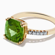 The 14K Yellow Gold Peridot and Diamond Ring features a large cushion-cut peridot at the center, accented by small diamonds set along the band on either side.