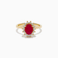 The 14K Yellow Gold Ruby and Diamond Halo Ring showcases an oval ruby center gemstone surrounded by a halo of round white diamonds, set in yellow gold and displayed against a white background.