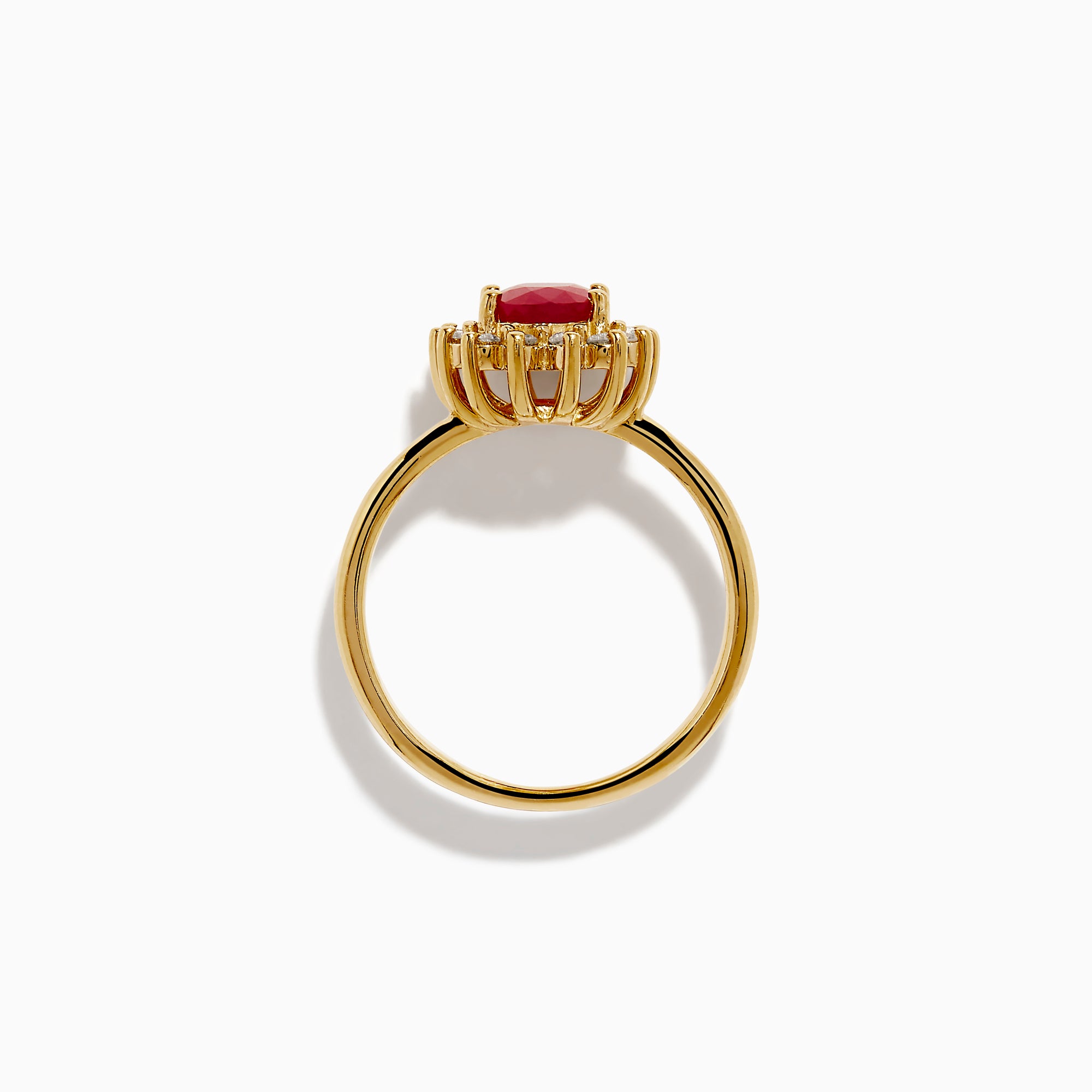 The 14K Yellow Gold Ruby and Diamond Halo Ring showcases an oval ruby center gemstone surrounded by a halo of round white diamonds, set in yellow gold and displayed against a white background.