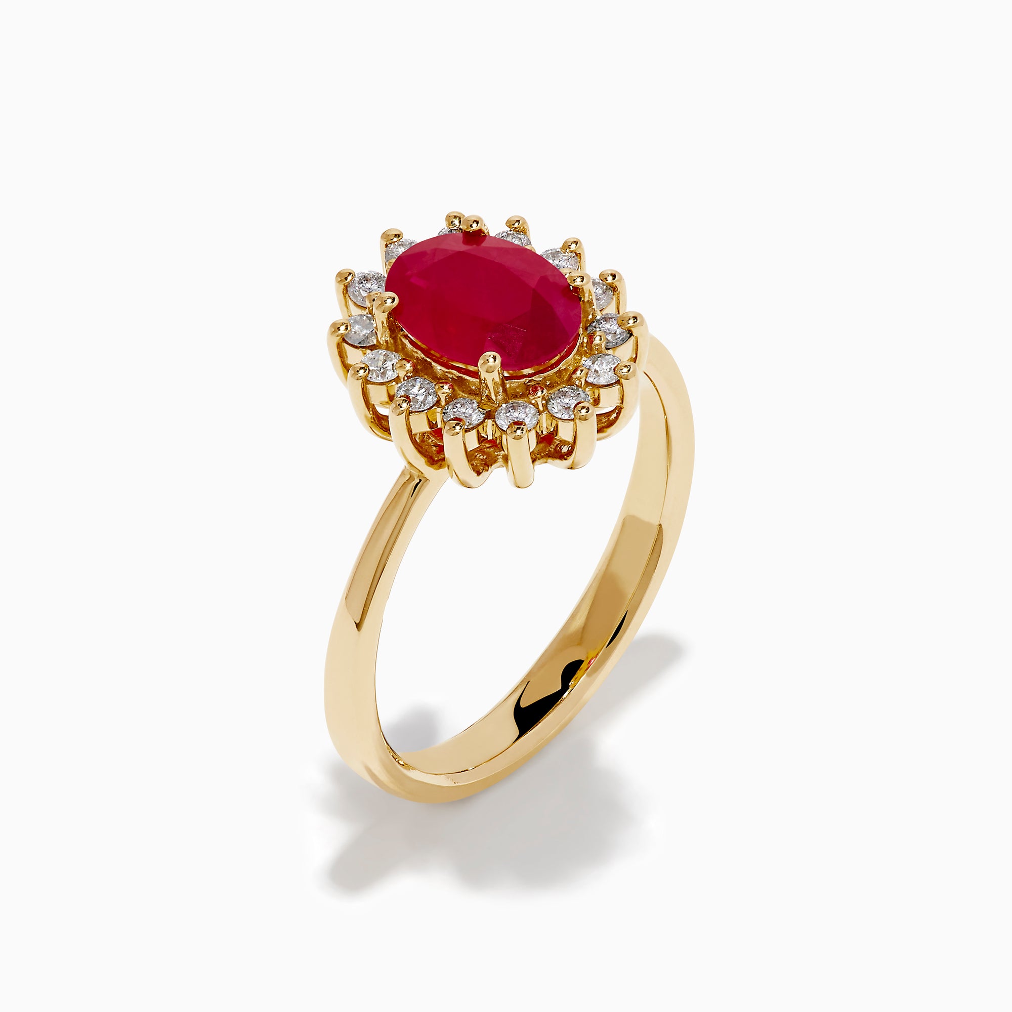 The 14K Yellow Gold Ruby and Diamond Halo Ring showcases an oval ruby center gemstone surrounded by a halo of round white diamonds, set in yellow gold and displayed against a white background.