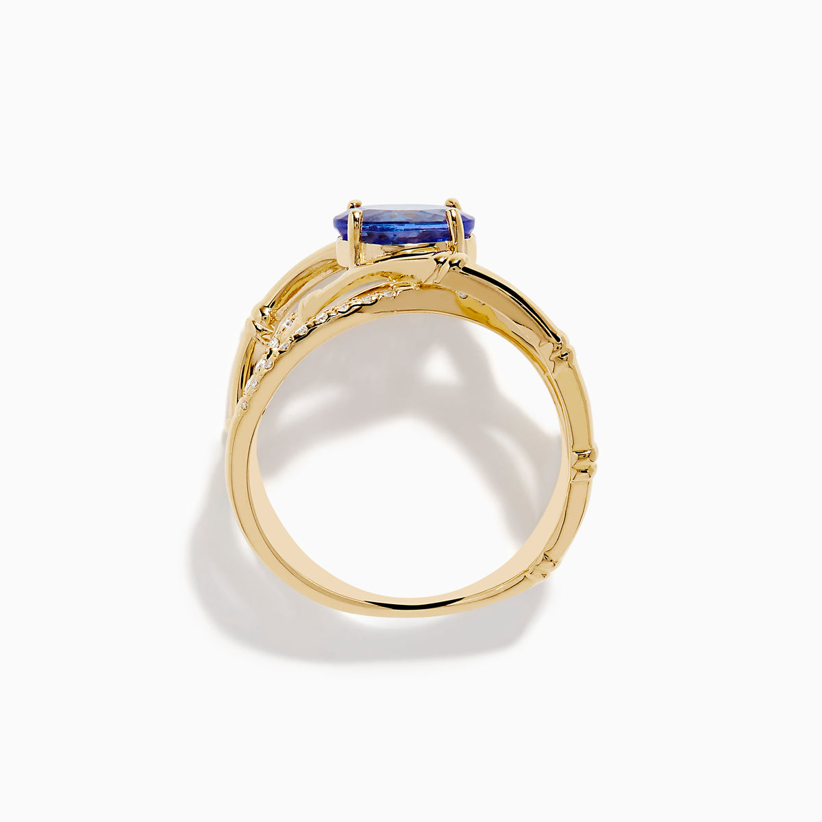 The Nahla 14K Yellow Gold Tanzanite and Diamond Criss Cross Ring features an oval tanzanite centerpiece and sparkling diamond crisscross bands, all set against a white background.