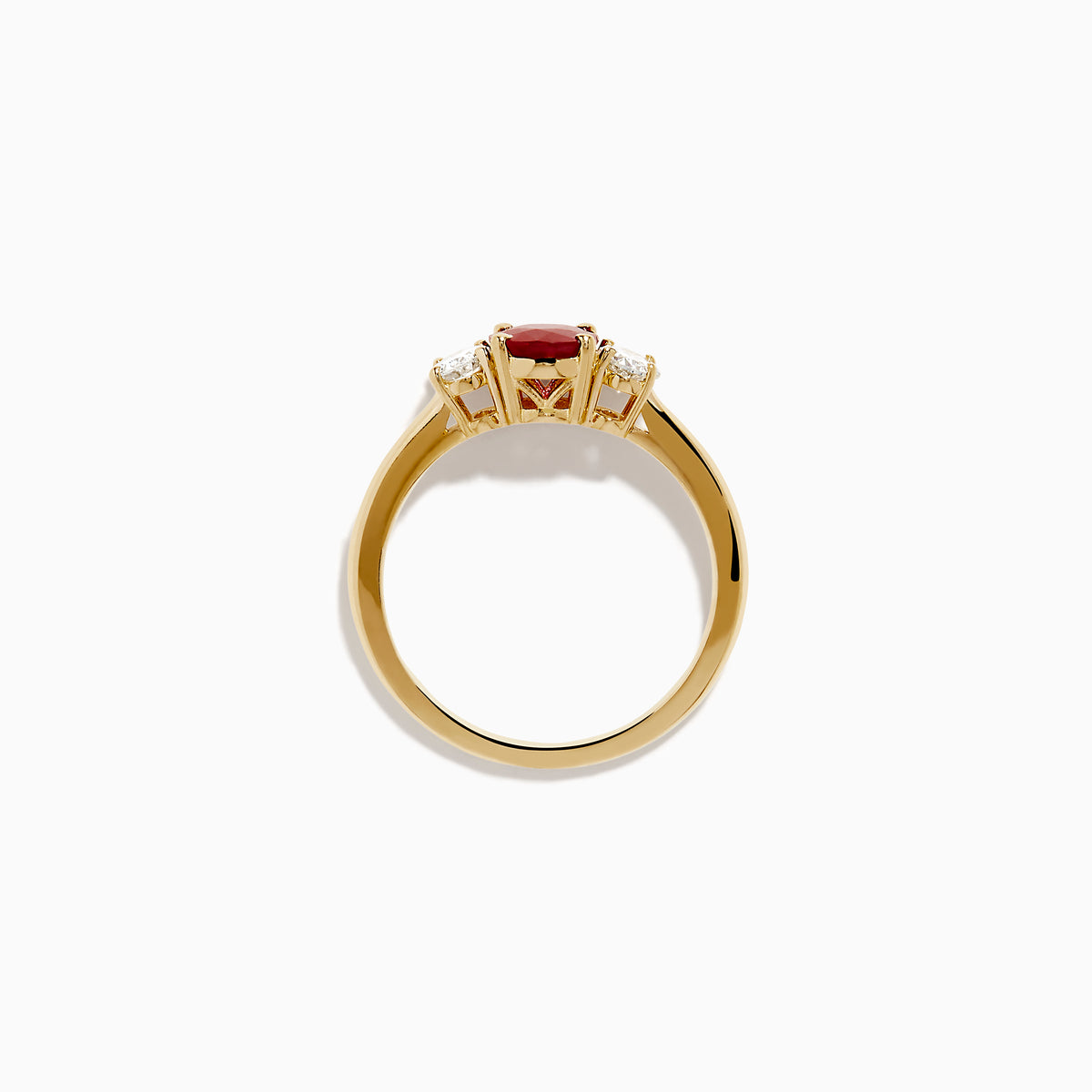The 14K Yellow Gold Ruby and Diamond Three-Stone Ring showcases a striking oval ruby center with two oval white diamonds, set in yellow gold and displayed on a white background.