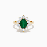 The 14K Yellow Gold Natural Emerald and Diamond Lady Di Ring showcases an oval emerald center surrounded by a halo of round white diamonds.
